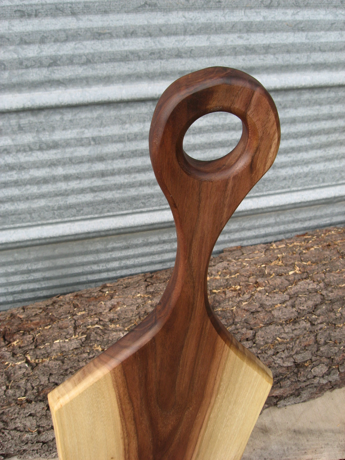 Black walnut charcuterie cheese board with handle.  Close up of handle.